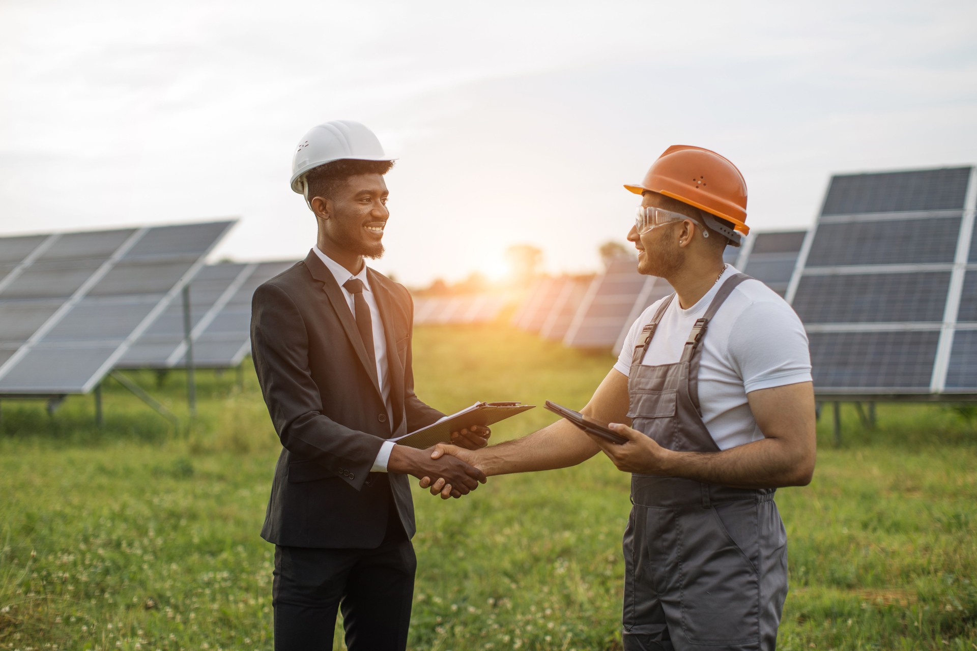 Inspector and engineer shaking hands among solar plant
