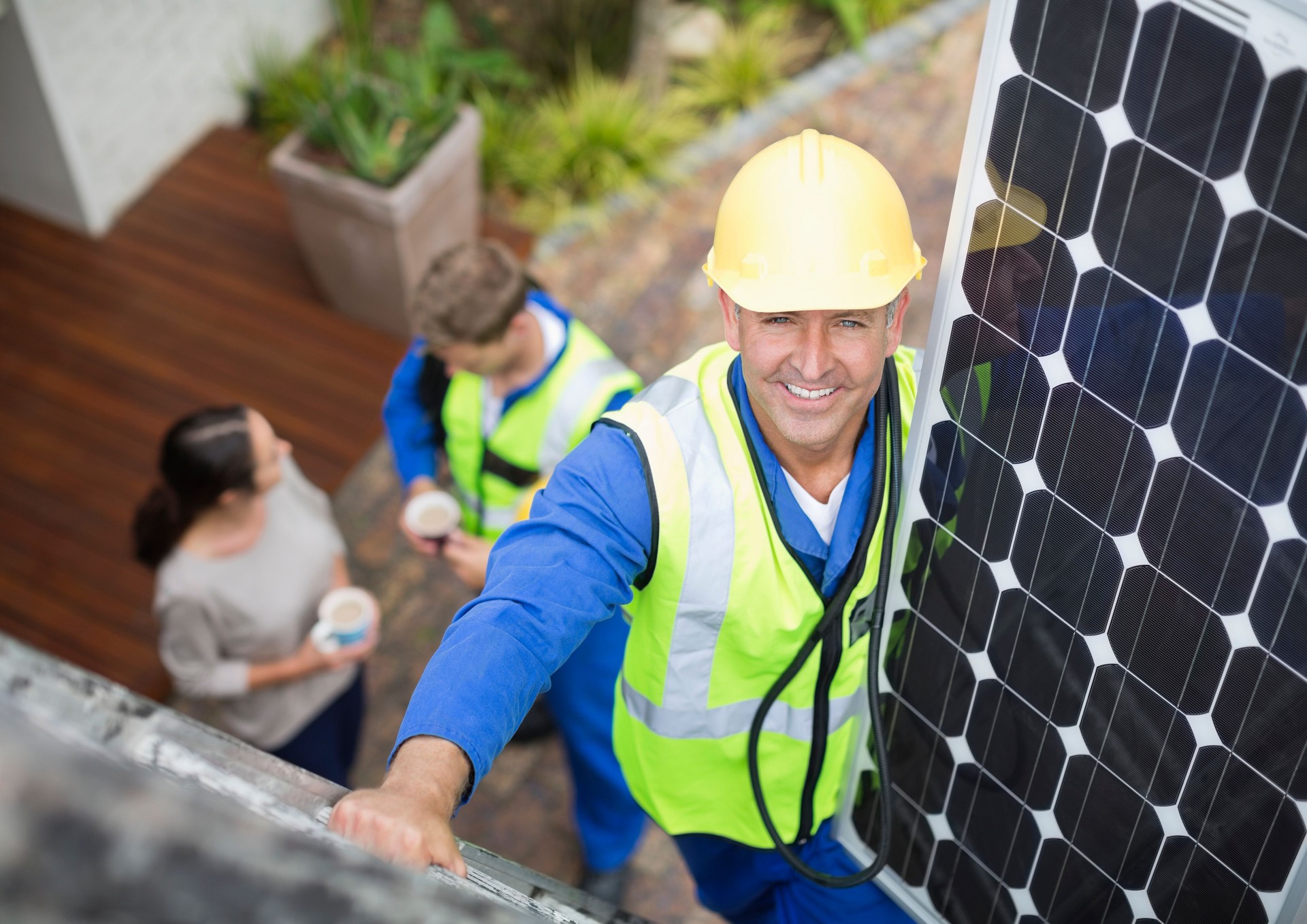 Worker installing solar panel on roof